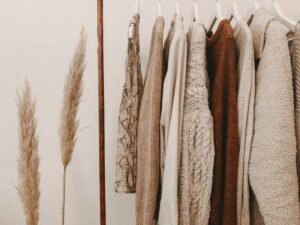 Closet minimalista com roupas em tons neutros e tecidos naturais — estilo praiano elegante